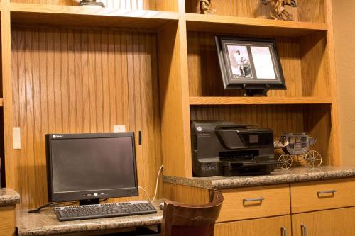 a desk with a computer and a printer and a monitor at AmericInn by Wyndham Medora in Medora