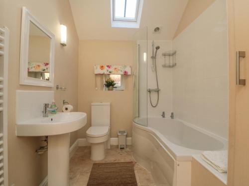 ein Badezimmer mit Waschbecken, Badewanne und Toilette in der Unterkunft Wood Cottage in Middlesbrough