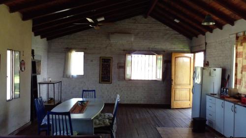 a kitchen with a table and a refrigerator at Los Arboles, casa completa a 5 minutos del Aeropuerto Ezeiza in Ezeiza