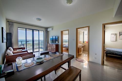 uma sala de estar com uma mesa e vista para o oceano em Guanlan Pavilion Seaview Homestay em Wenchang