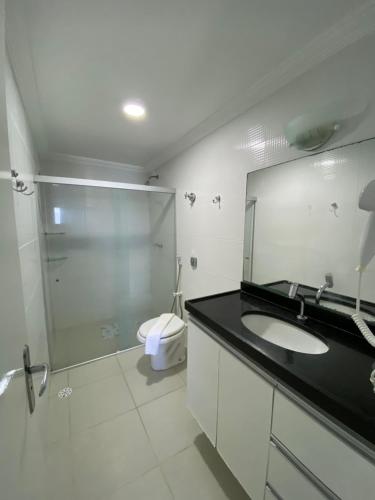 a bathroom with a shower and a sink and a toilet at Apart Hotel Marinas Tamandaré in Tamandaré