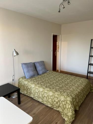 Un dormitorio con una cama con almohadas azules y una escalera en Cosylocation Jean Bart 59, en Rennes