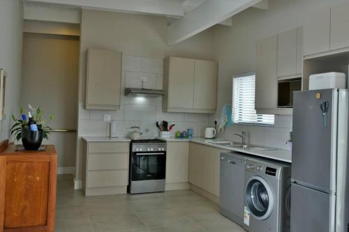 a kitchen with a refrigerator and a dishwasher at The Whale and Waddler in Kleinmond