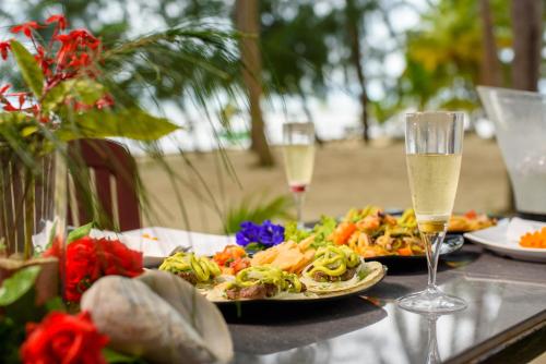 a table with two plates of food and glasses of champagne at Kiki Coconut Beach Resort in Phú Quốc