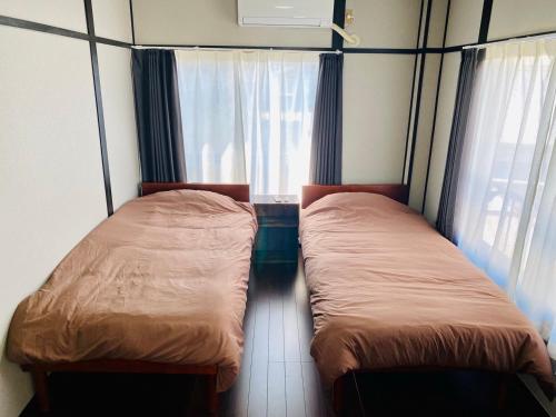 洲本市にあるAZホテルin洲本の窓付きの小さな部屋のベッド2台