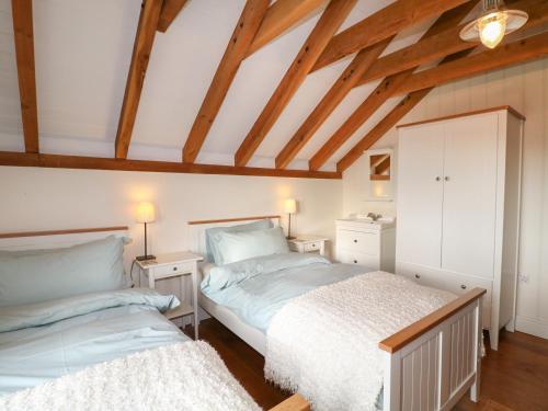 two beds in a attic bedroom with wooden beams at The Milk House in Wirksworth