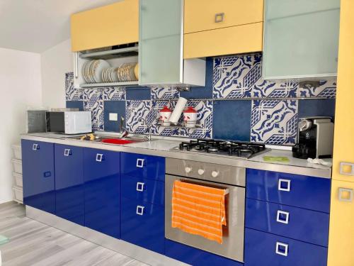 a kitchen with blue cabinets and an orange towel at Le case di Fiò in Sciacca