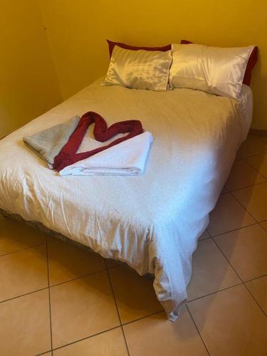 a bed with two towels in the shape of a heart at Toke homestay nr 37 omatjene street Cimbabacia in Academia