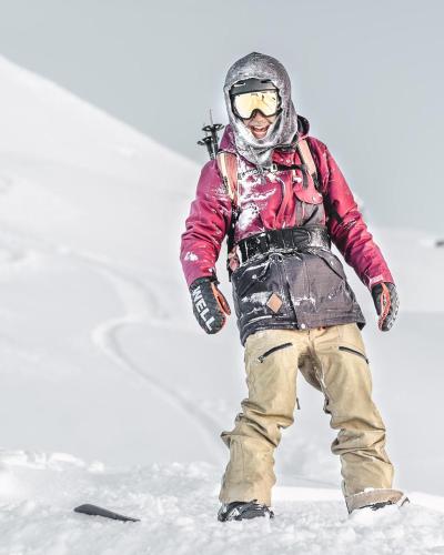 a person is standing in the snow at Hotel Alpensonne - Panoramazimmer & Restaurant in Arosa