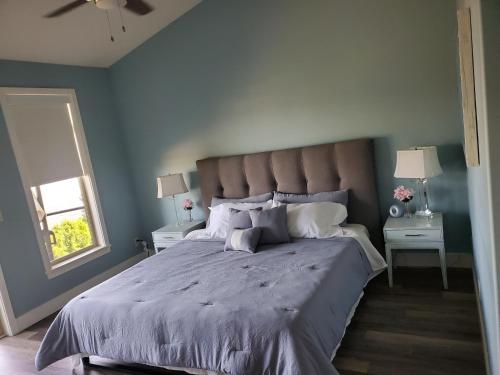 um quarto com uma cama grande e paredes azuis em Wine Country Luxury Waterfront Condo em West Kelowna