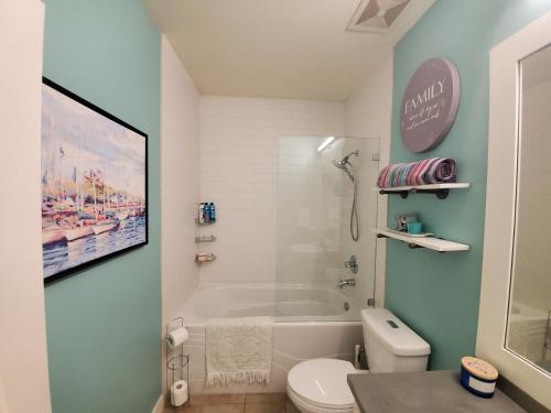 a bathroom with a tub and a toilet and a sink at Wine Country Luxury Waterfront Condo in West Kelowna