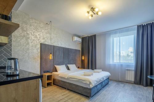 um quarto com uma cama e uma grande janela em Гостиниц NET на Большевистской em Novosibirsk