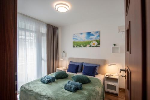 a bedroom with a bed with blue pillows on it at Lovely apartman- free parking in Pécs