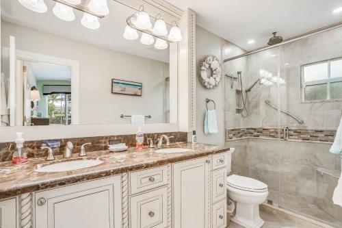 a bathroom with a sink and a shower and a toilet at Palm Breeze Bliss in Marco Island