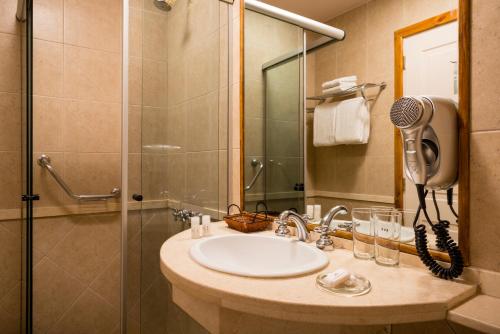 a bathroom with a sink and a shower at Sol Arrayan Hotel & Spa in Villa La Angostura