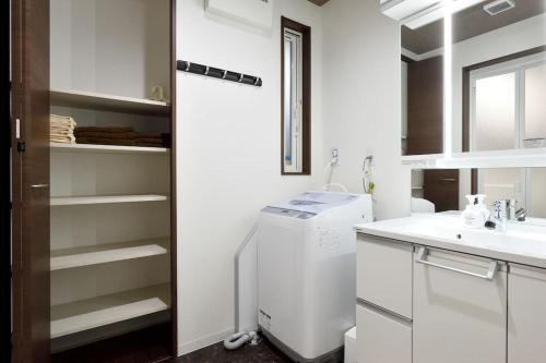 a white kitchen with a sink and a refrigerator at Ya -MIYABI in Kyoto