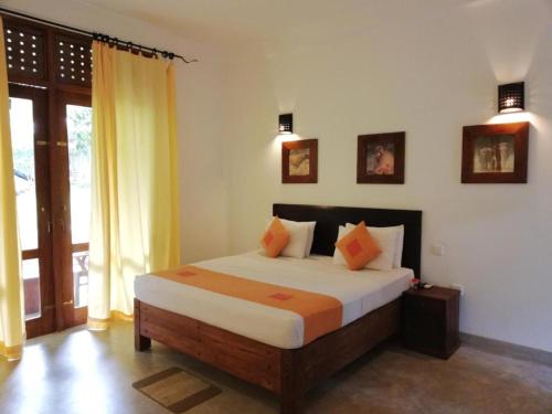 a bedroom with a bed and a large window at Nil Diya Mankada Safari Lodge in Udawalawe