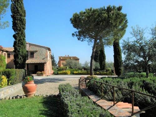 a garden with a fence and a house and trees at Hideaway Near San Gimignano in Bagnolo