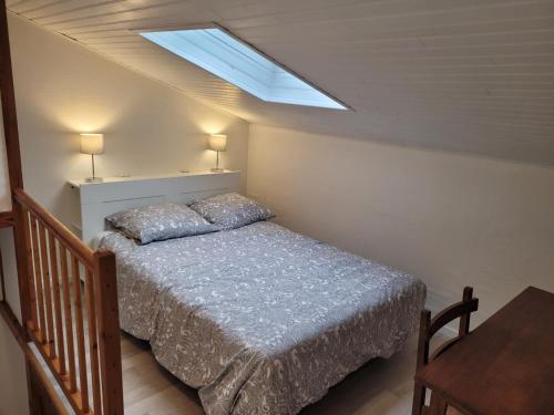 a bedroom with a bed and a skylight at Gîte Mélisse in Mouilleron-le-Captif