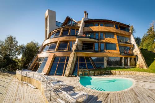 a large building with a pool in front of it at Sol Arrayan Hotel & Spa in Villa La Angostura