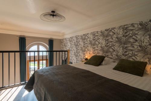 艾克斯萊班的住宿－Les petits boudoirs bernascon，一间卧室配有一张带花卉壁纸的大床