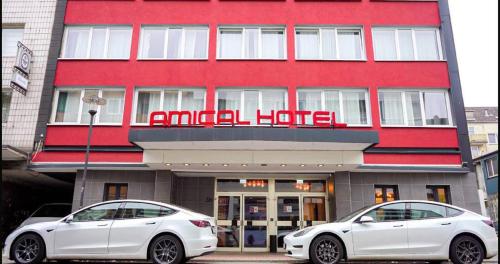 two white cars parked in front of a hotel at Amical Hotel Hagen - Am Hauptbahnhof in Hagen