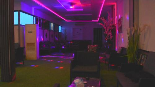 a room with purple lights on the floor and chairs at Florida Inn Hotel in Najran