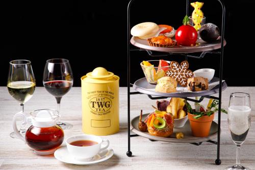 a table with two plates of food and glasses of wine at Shin Osaka Esaka Tokyu REI Hotel in Suita
