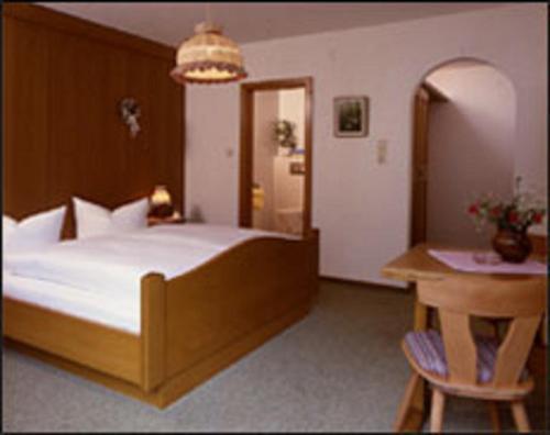 a bedroom with a large bed and a table at Gästehaus Annabell und Barbara in Sautens
