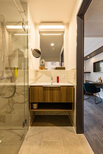 a bathroom with a sink and a shower at MASEVEN München Messe Dornach in Aschheim