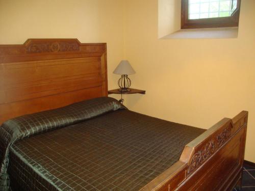 um quarto com uma cama com uma cabeceira de madeira em Luxury country nel Cilento e piscina em Monte San Giacomo