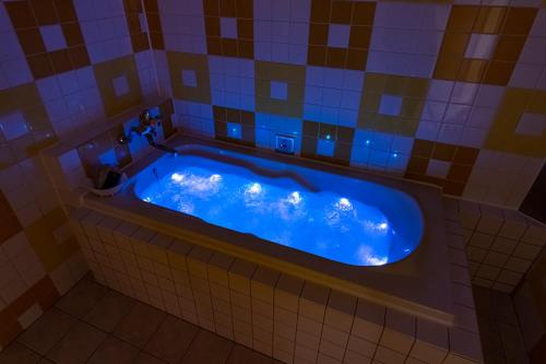 y baño alicatado con bañera azul. en Koriyama Flower Style, en Tenri