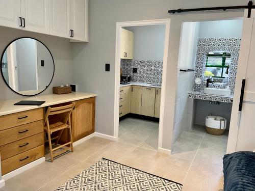 eine Küche mit einem Spiegel, einem Waschbecken und einer Theke in der Unterkunft Sandra's Guest House in Langebaan