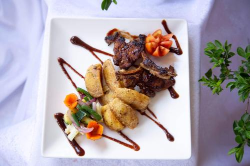 a plate of food on a white plate at The Sparrow Hotels in Soroti