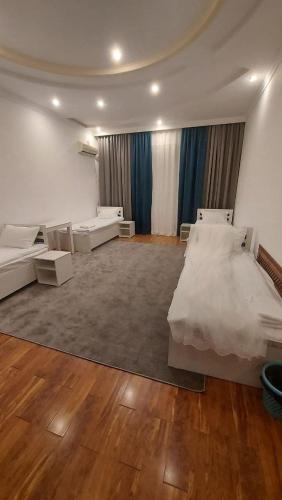 a large room with two beds and a couch at GUESTO HOSTEL in Tashkent
