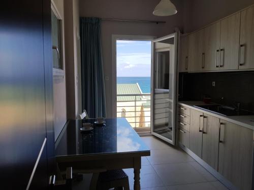 kuchnia ze stołem i widokiem na ocean w obiekcie Heraklion Old Port Apartments w Heraklionie