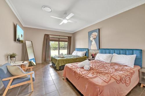 a bedroom with a large bed and a chair at Hunter Valley Vineyard Large Family Farm Houses - Ironstone Estate Lovedale in Lovedale
