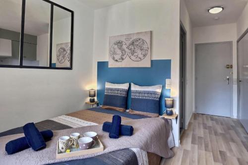 een slaapkamer met een groot bed met blauwe kussens bij Studio vue sur le clocher, au calme Moustiers #3 in Moustiers-Sainte-Marie