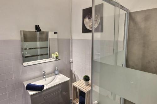 een witte badkamer met een wastafel en een douche bij Studio vue sur le clocher, au calme Moustiers #3 in Moustiers-Sainte-Marie