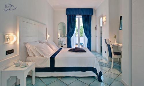 a bedroom with a bed and a table and a desk at Hotel Villa Durrueli Resort & Spa in Ischia