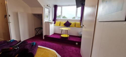 a room with a bed and a window and a table at Holly Cottages in Bowness-on-Windermere