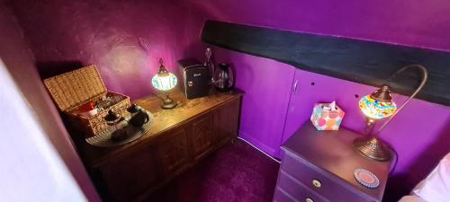 a room with purple walls and a table with lights at Holly Cottages in Bowness-on-Windermere