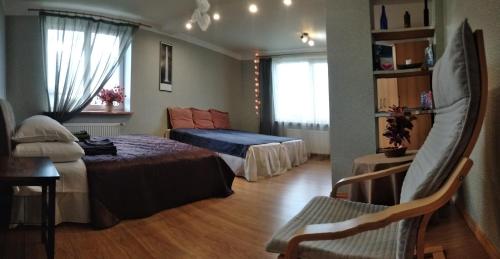 Pokój hotelowy z 2 łóżkami i krzesłem w obiekcie Apartment by the sea (5 minute walk) w mieście Tūja