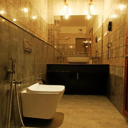 a bathroom with a toilet and a sink at Napier Heritage By Velvet Hotels in Cochin