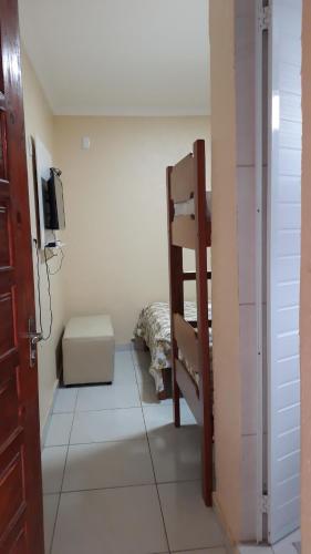 a small room with a bunk bed and a television at Pousada Restaurante Sol de Liz in Fortaleza