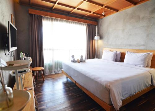 a bedroom with a large bed and a large window at Greenhost Boutique Hotel Prawirotaman in Yogyakarta