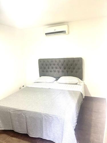 a bedroom with a bed with a gray headboard at Departamento Alassio in Tigre