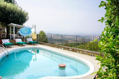 a swimming pool with two chairs and an umbrella at Antica Pietra holiday house with pool in Montaione
