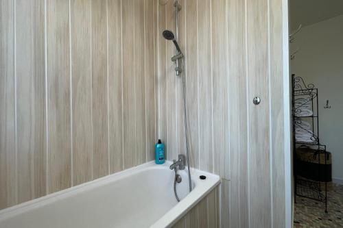 une baignoire avec une douche avec une bouteille bleue dessus dans l'établissement Apartment 