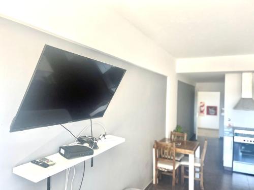 a flat screen tv hanging on a wall in a living room at Departamento Alassio in Tigre